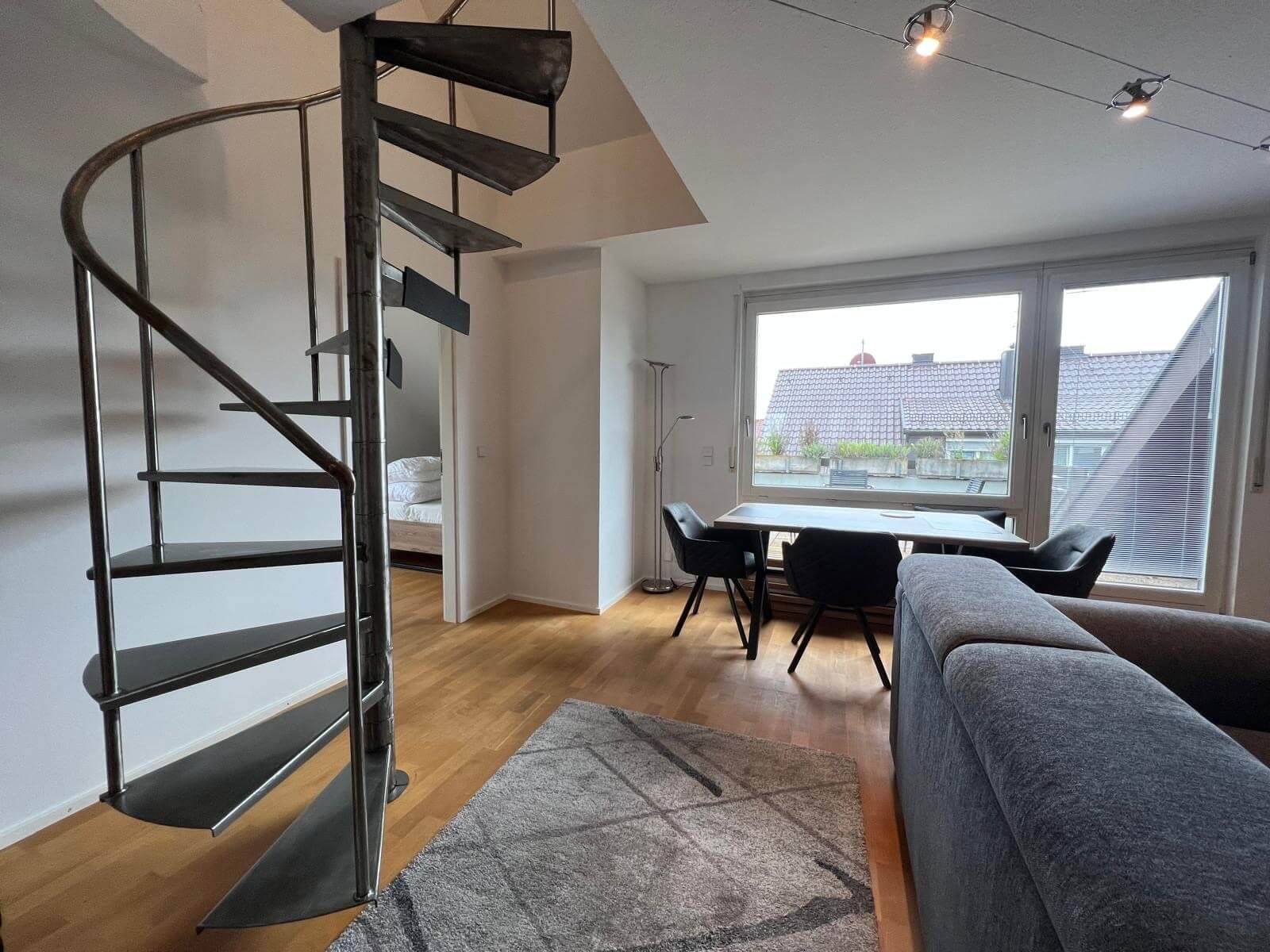 Offene Wohnküche mit Wendeltreppe in der Apartment-Wohnung